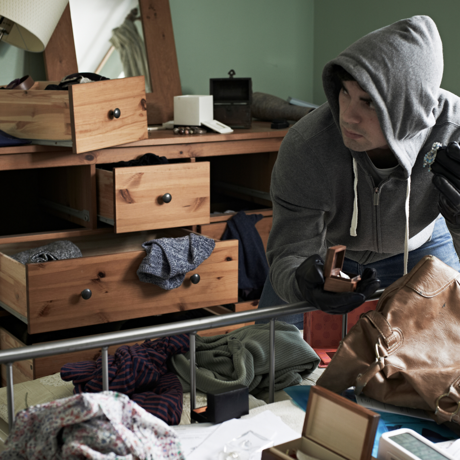 man going through drawers of dresser